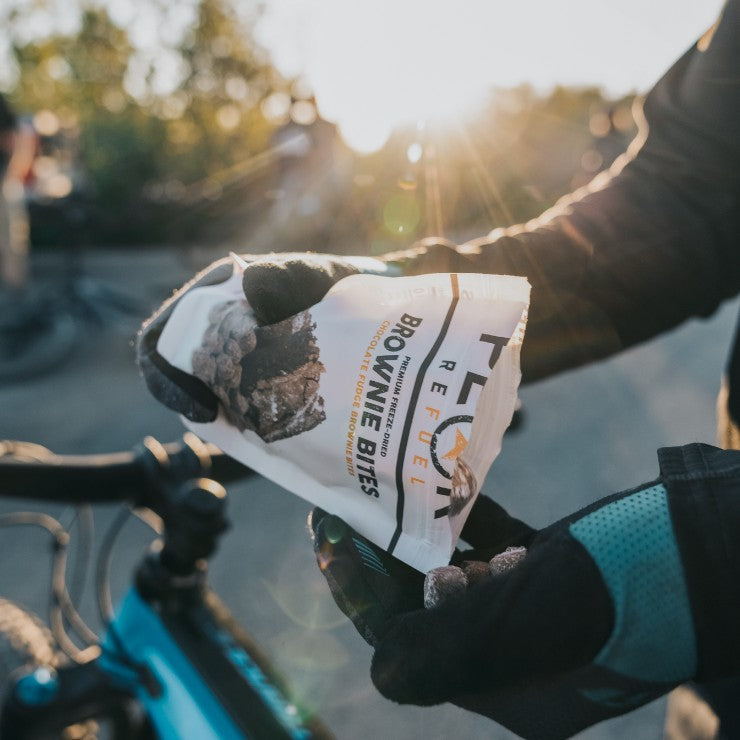 A person holding a bag of food, possibly the undefined, outdoors with a bicycle in the background.