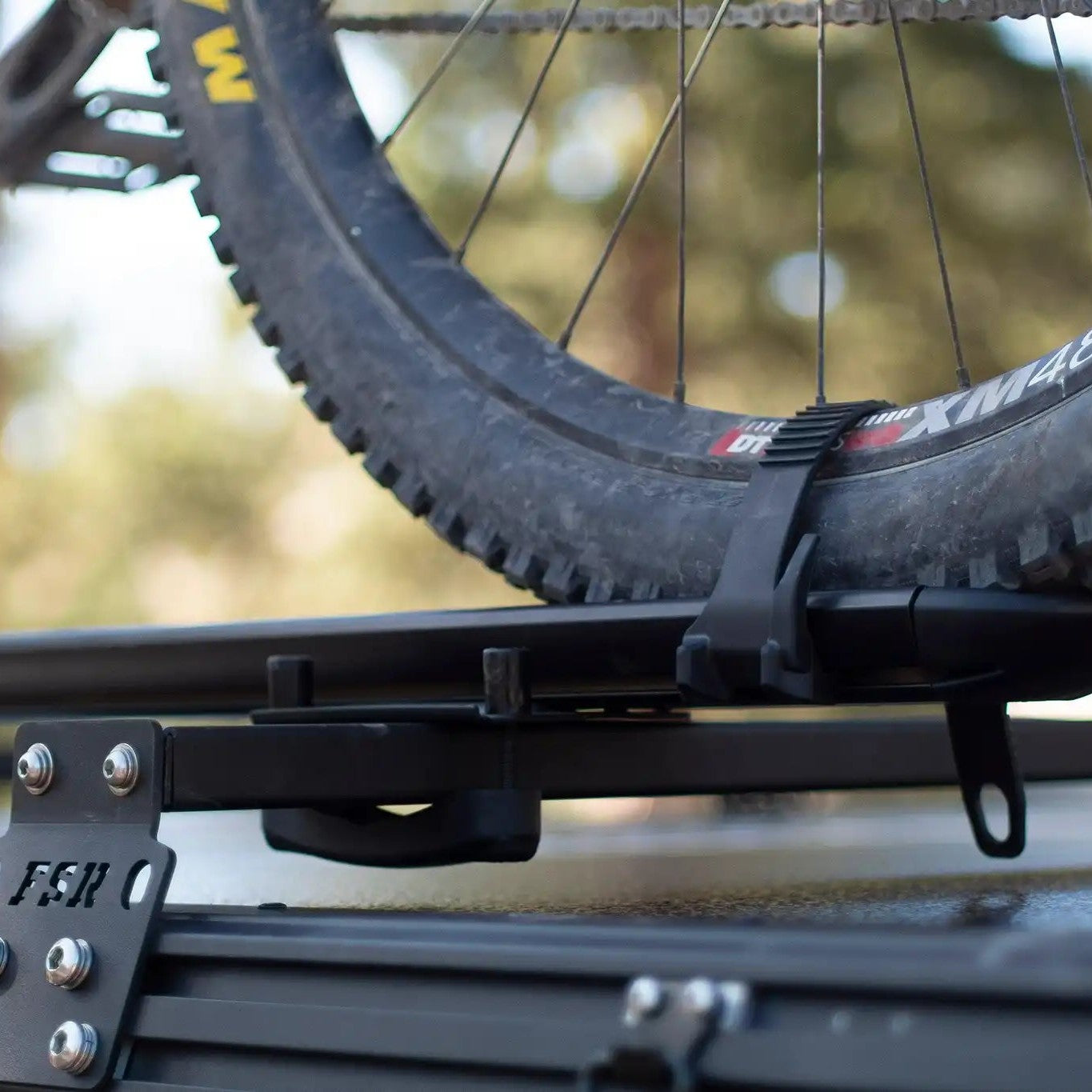Close up of a bike mount installed on FSR Hardshell Series Crossbars mounted on a Free Spirit Recreation hard shell rooftop tent with a bike mount secured.