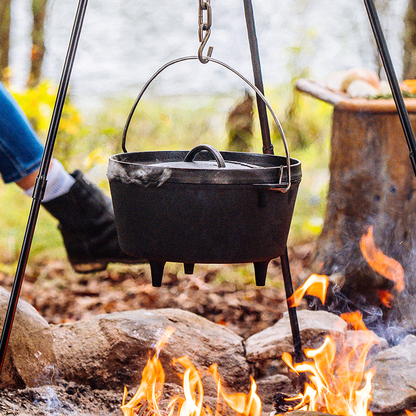 Dutch oven hanging over fire using the Lodge Camp Tripod.