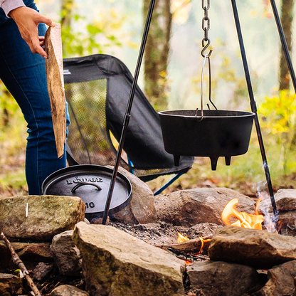 Dutch oven hanging over fire using the Lodge Camp Tripod.
