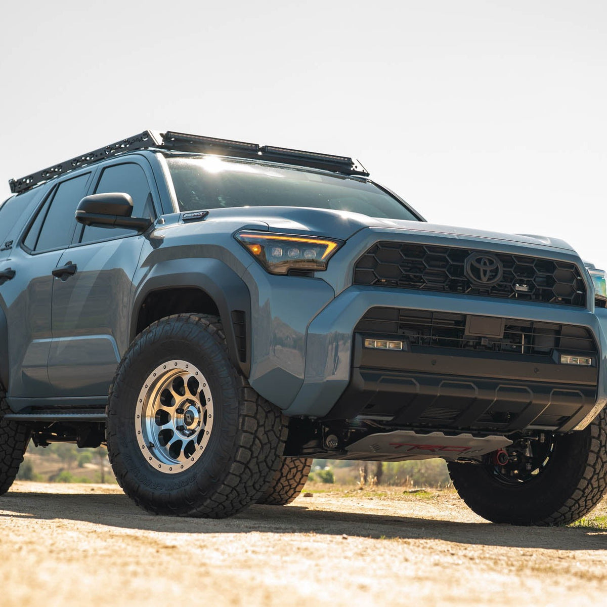 6th Gen Toyota 4Runner Roof Rack Light Cutout installed on a dirt road with a clear sky background