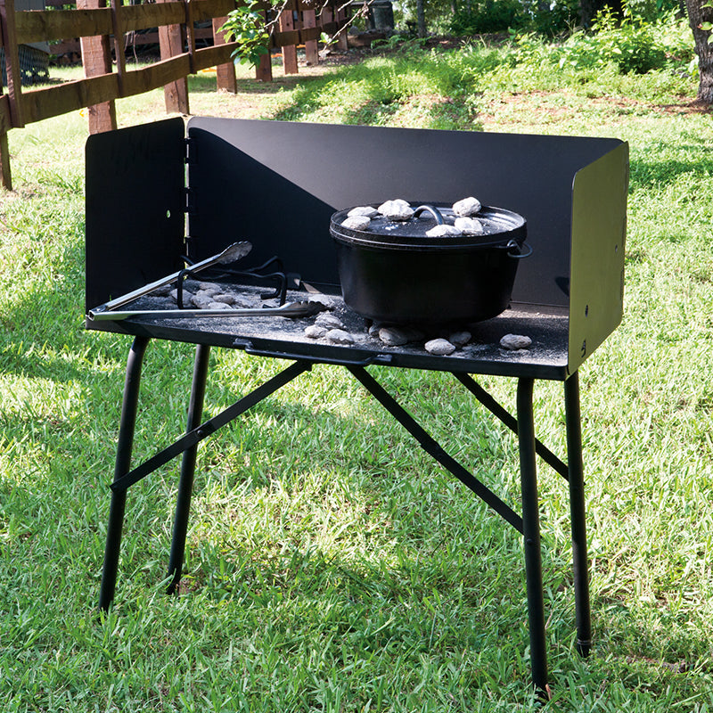 Table set up in grassy park, with a dutch oven.