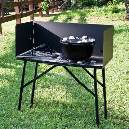 Table set up in grassy park, with a dutch oven.