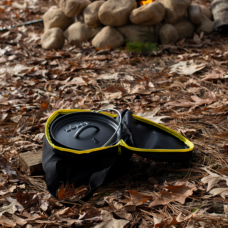 Camp dutch oven inside tote bag with top open at campsite.