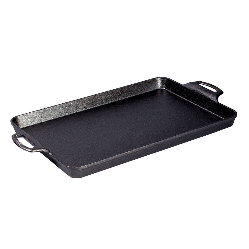 Black cast iron, rectangular pan with handles and shallow edges.