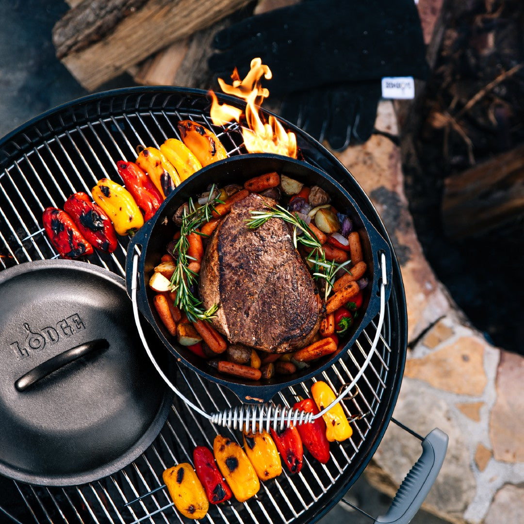 Beef chuck roast being prepared in dutch oven on grill.