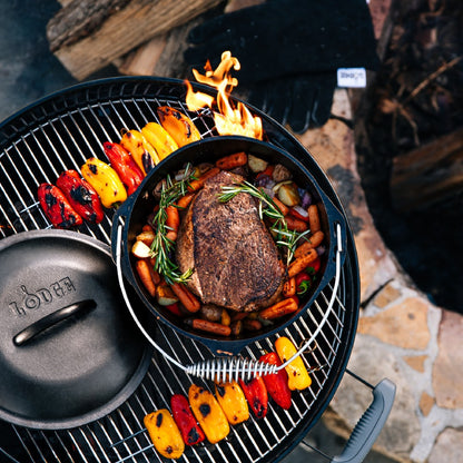 Beef chuck roast being prepared in dutch oven on grill.