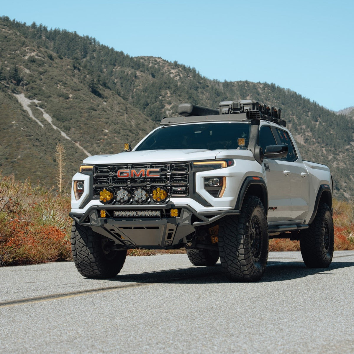 GMC Canyon Tube Front Bumper installed on truck driving on the road with fall scenery