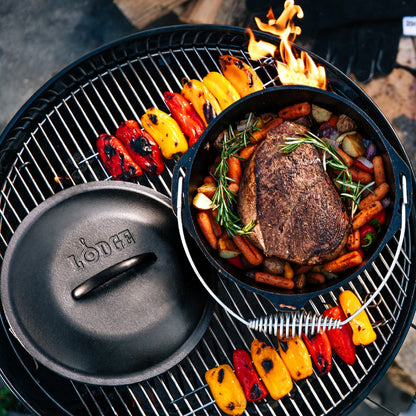 Beef chuck roast being prepared in dutch oven on grill.