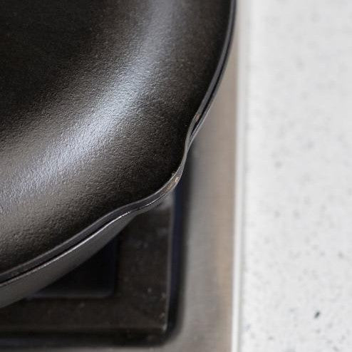 Close-up view of lid showing the lid is shaped to cover pour spout on skillet.