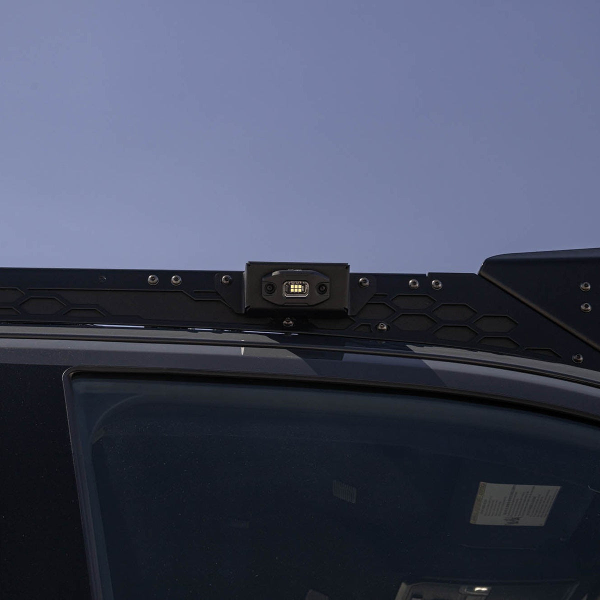 Size reference with the DV8 Micro Elite Utility Light mounted on a vehicle roof rack.