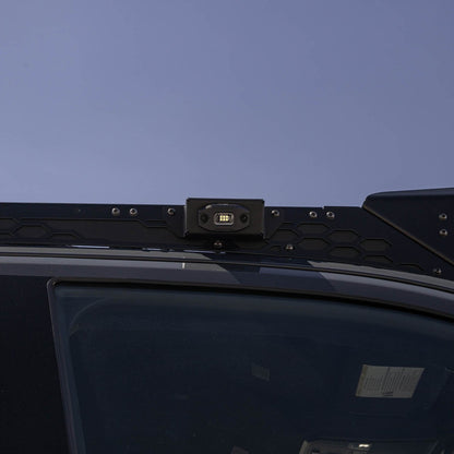 Size reference with the DV8 Micro Elite Utility Light mounted on a vehicle roof rack.