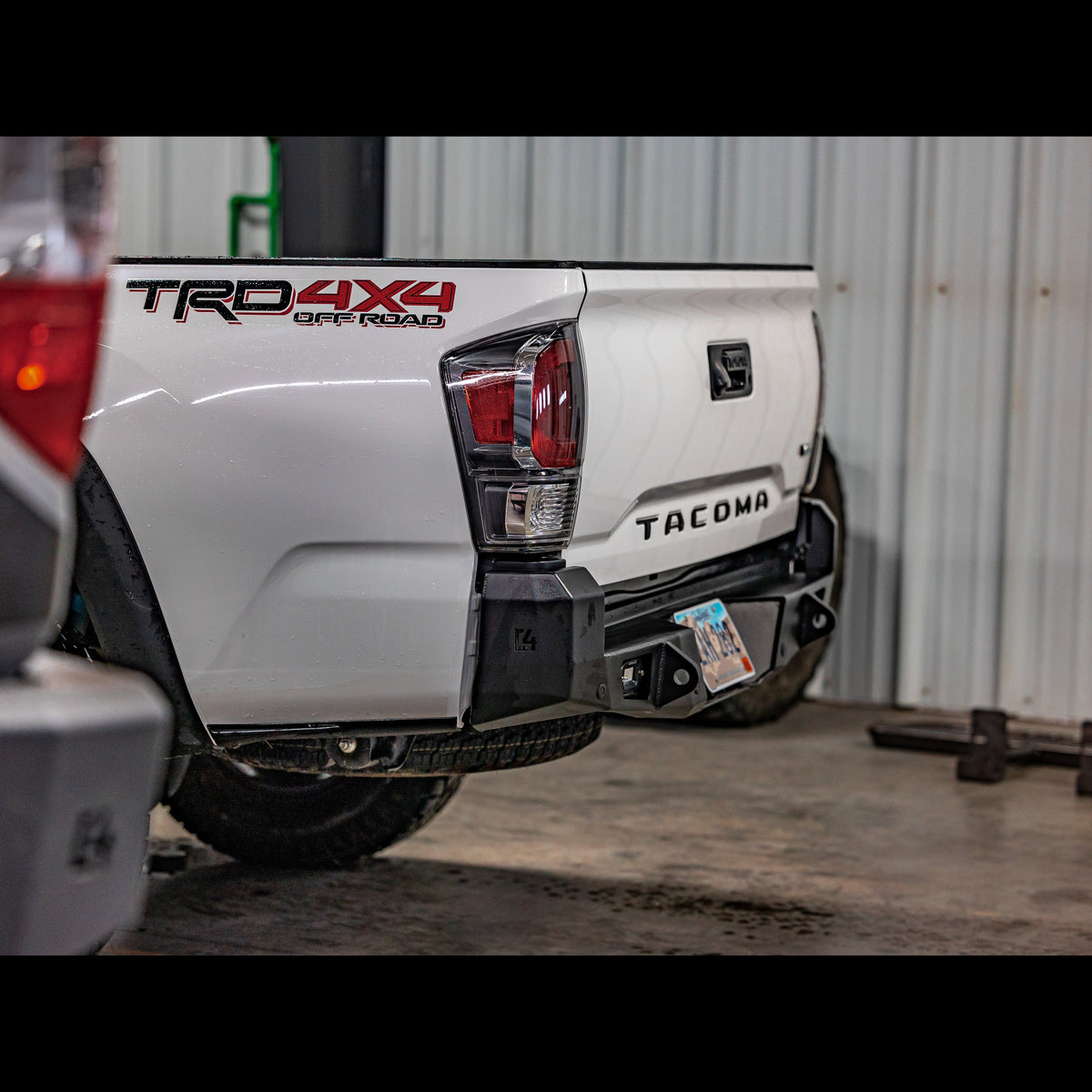 Black C4 Overland bumper installed on a white Tacoma.