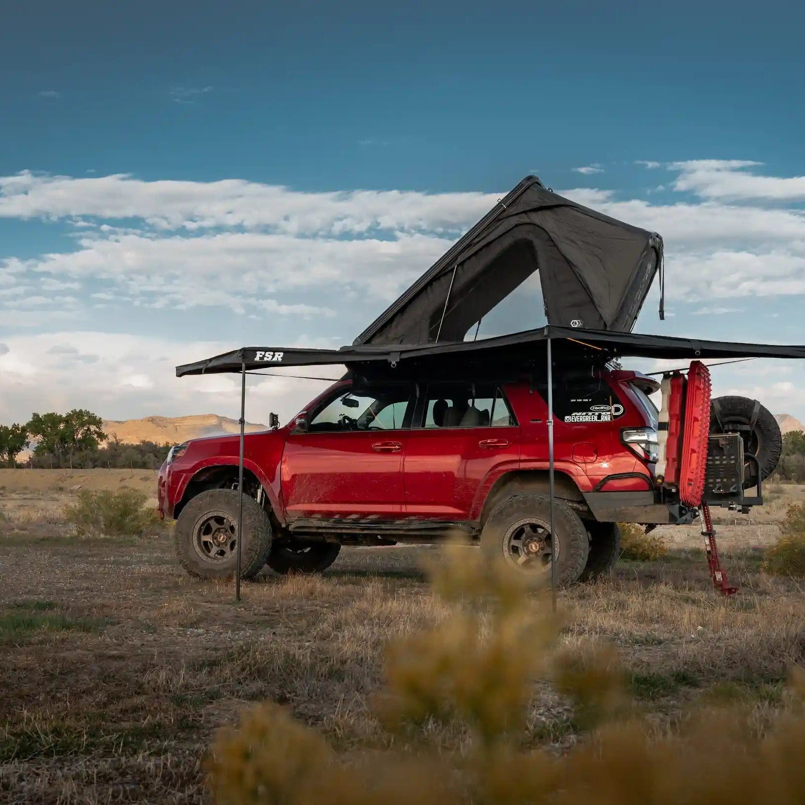 Red Toyota 4Runner with a FSR 180 degree Awning V2 mounted to a Free Spirit Recreation with awning deployed while camping in a desert setting