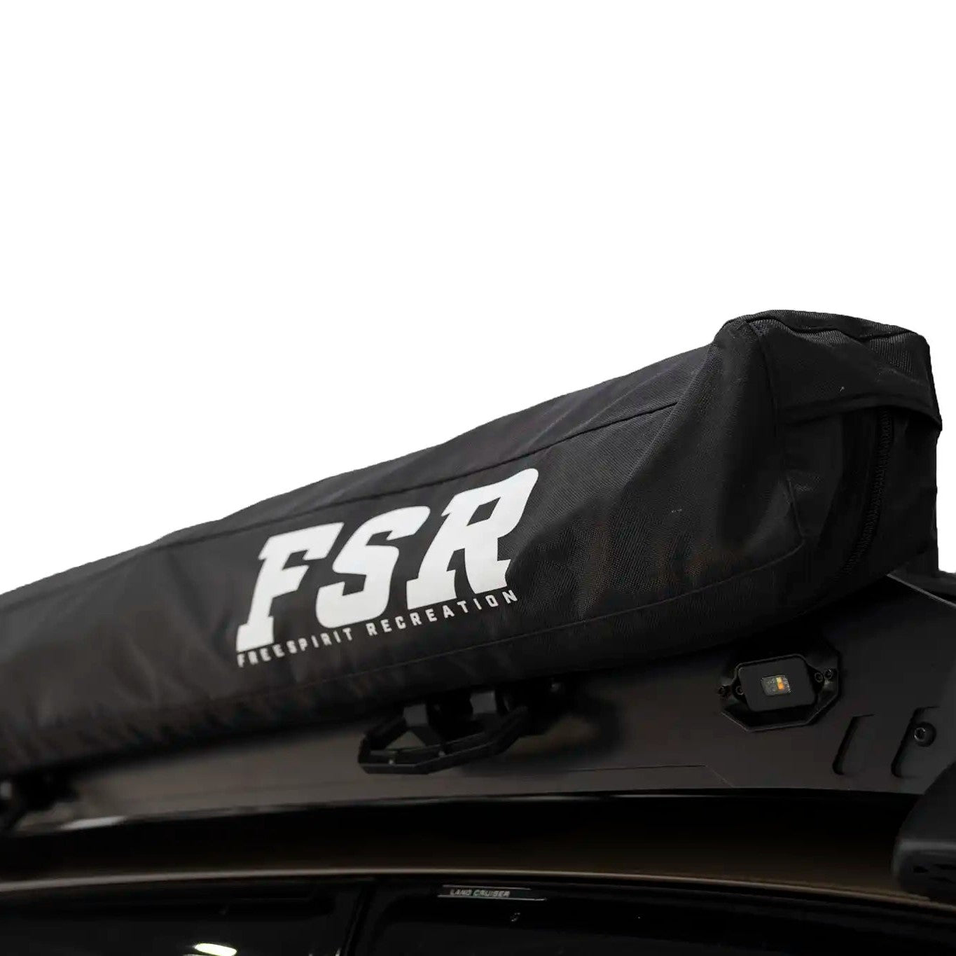 Close up photo of the stowed FSR 180 Degree Car Awning from Freespirit Recreation mounted on a overland 4wd vehicle roof rack for camping