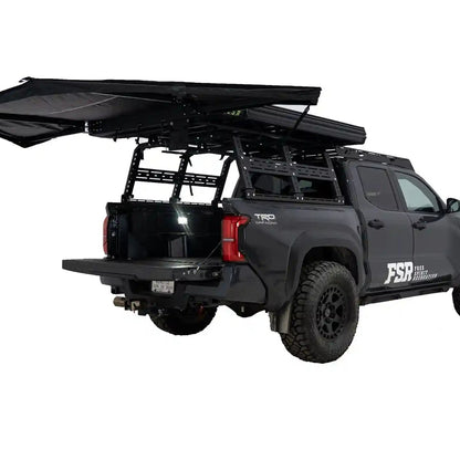 FSR 180 Tailgate Awning mounted and deployed at the rear of a black Toyota Tacoma overlanding setup for use as a rear car awning