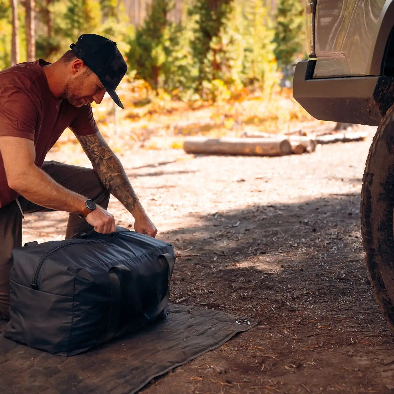 Man unpacking the FSR 270 Awning Walls from the included storage bag to install them on his Freespirit Recreation 270 degree awning while camping in a forested setting