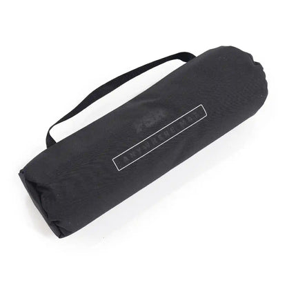 Black rolled-up FSR Anywhere Camping Mat in storage bag with strap on a white background