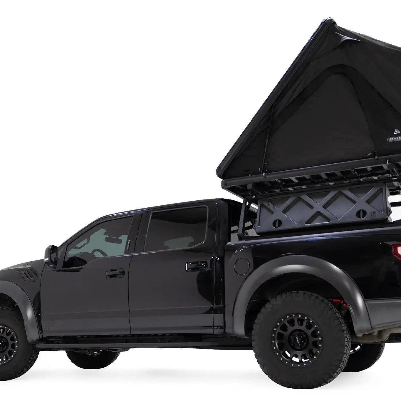 Lower angle photo of the FSR Aspen Lite XL Rooftop Tent by Free Spirit Recreation installed on a black Ford Raptor truck bed rack.