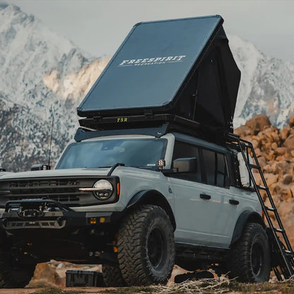 Ford Bronco with an FSR Aspen Pro Standard rooftop tent installed on the roof rack and setup in a mountainous campsite