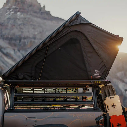 FSR Aspen Pro XL rooftop tent set up on a truck bed rack against a mountainous landscape at sunset.