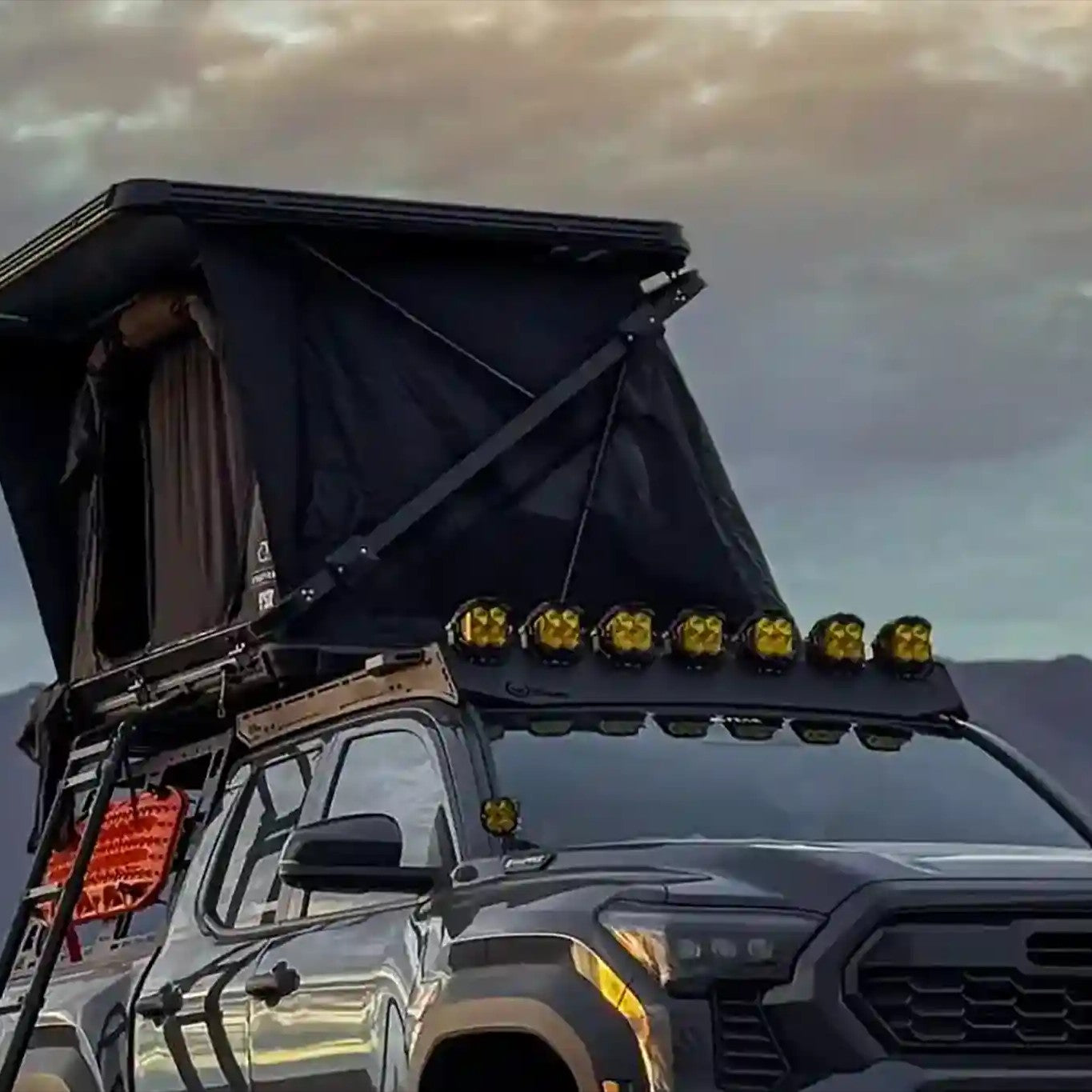 Toyota tacoma with an FSR Evo XL rooftop tent setup on the bed rack against a mountainous landscape
