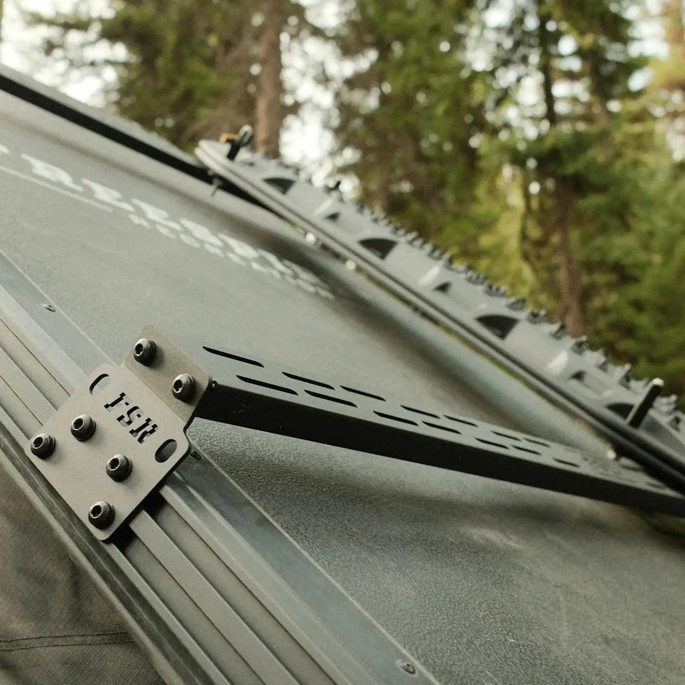 Close up of the mounting plates for the FSR Hardshell RTT Crossbars installed on a Freespirit Recreation hard shell roof top tent for cargo storage