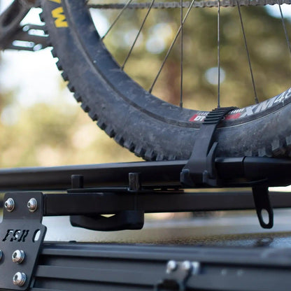 Close up of a bike mount installed on FSR Hardshell Series Crossbars mounted on a Free Spirit Recreation hard shell rooftop tent with a bike mount secured.