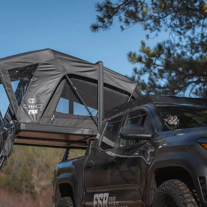 Free Spirit Recreation Nova Standard rooftop tent installed on a Tacoma bed rack and setup in a wooded campsite