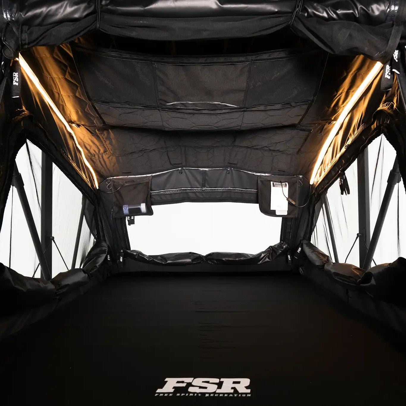 Interior photo of FSR Nova rooftop tent deployed with the interior lights on.