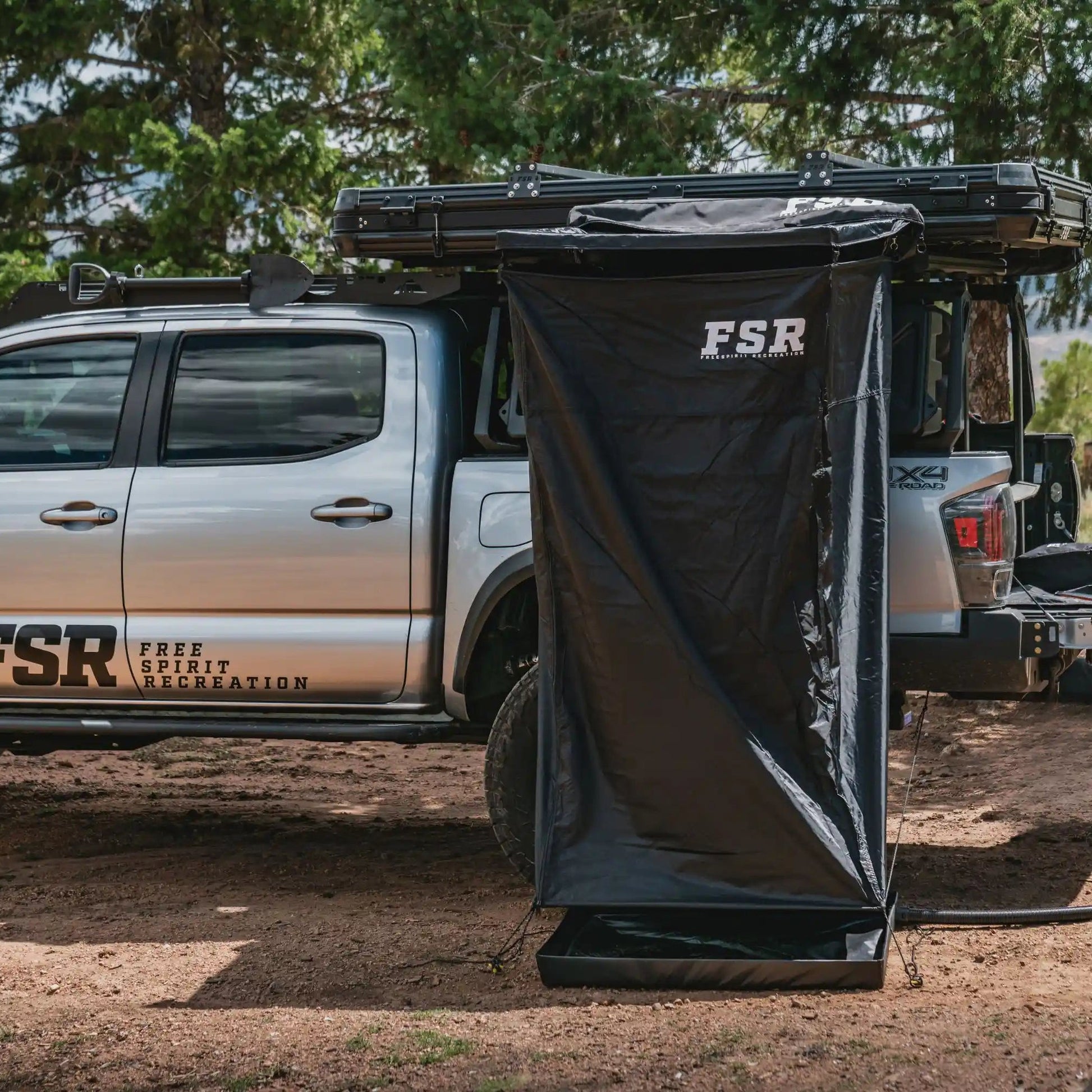 FSR Overland Shower Awning installed on a Toyota Tacoma overlanding setup in a wooded campsite