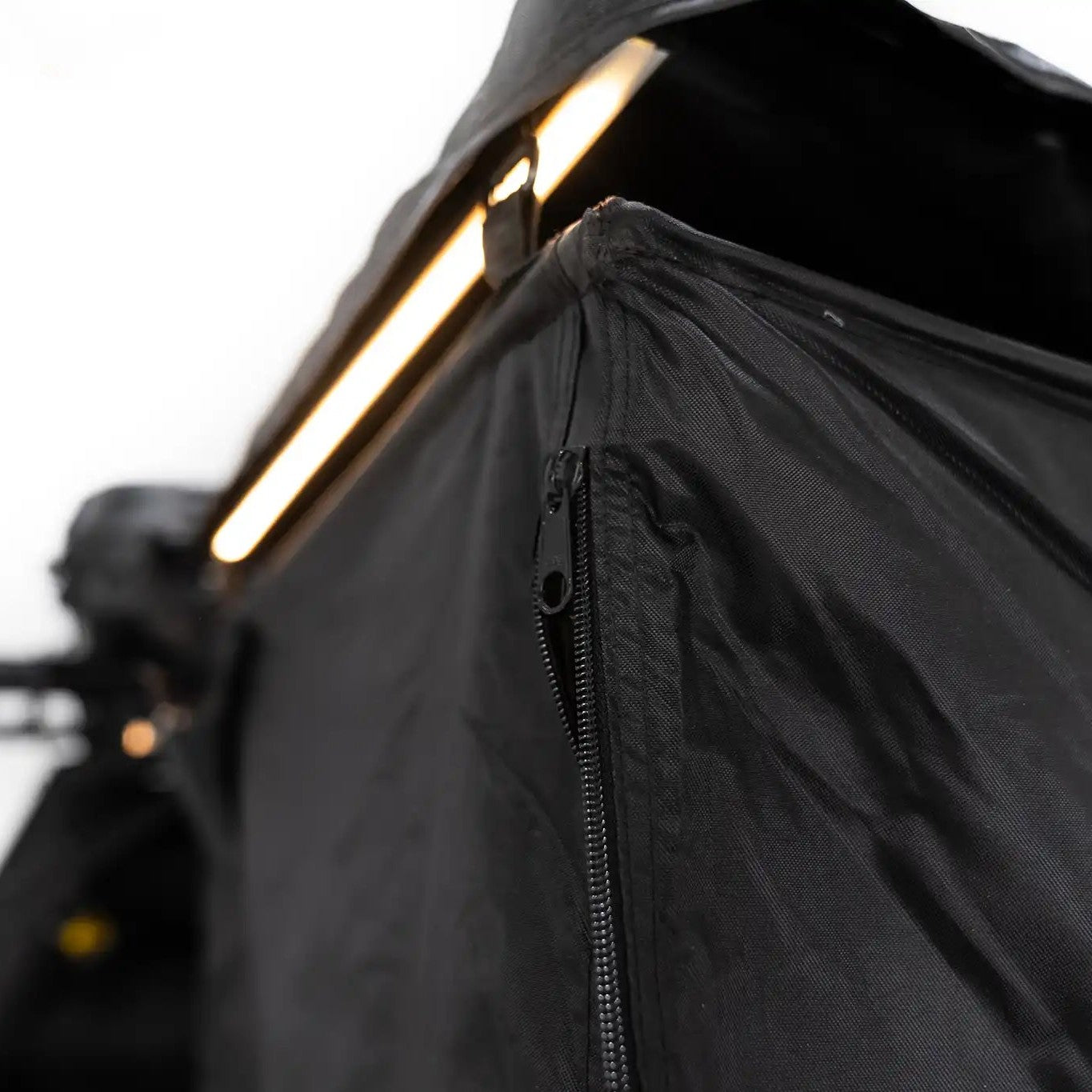 Close up image of the zipper on the FSR Shower Awning with built in LED light illuminated in the background