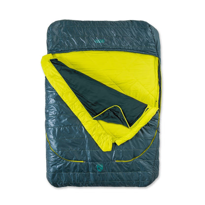 The NEMO Equipment Jazz™ Double Synthetic Sleeping Bag is shown spread out in dark teal and bright yellow, with its quilted insulated top layer partially folded back to reveal the inner lining.
