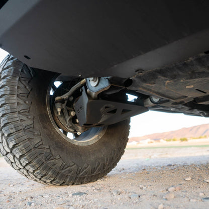 Close-up of bronco with the A-Arm skid plate on a gravel surface.