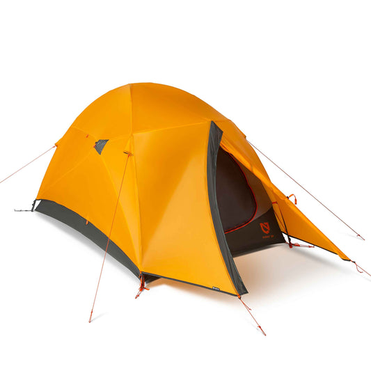 A bright orange NEMO Equipment Kunai™ 3–4 Season Backpacking Tent, designed for versatile year-round backpacking, is set up with its door partially open and guy lines staked out against a plain white background.